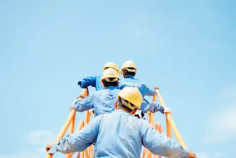 Marine crew in hard hats working at height above the water